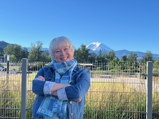 Jessica Shields Flowers on a speaking trip, standing outdoors with Mt Rainier in the background